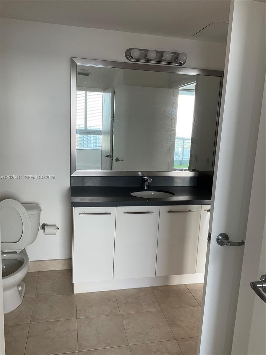 90 Southwest 3rd Street, Unit 3708 Miami, FL 33130 - Photo 7 of 13 a bathroom with a sink a toilet and a mirror