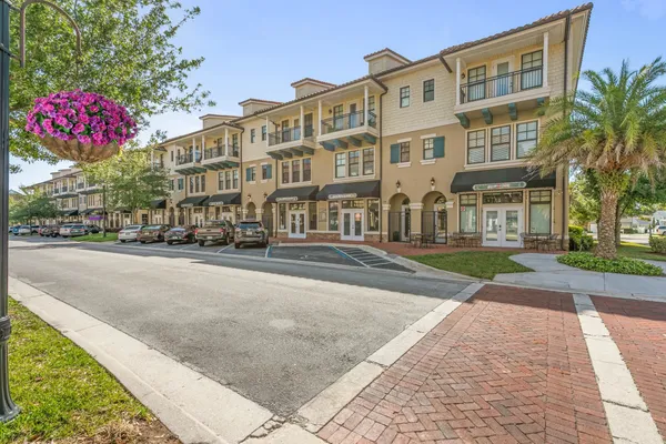 a front view of multi story residential apartment building with yard and sign board