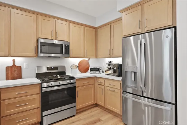 a kitchen with white cabinets sink and stainless steel appliances