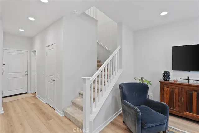 a view of a livingroom with furniture a flat screen tv and wooden floor