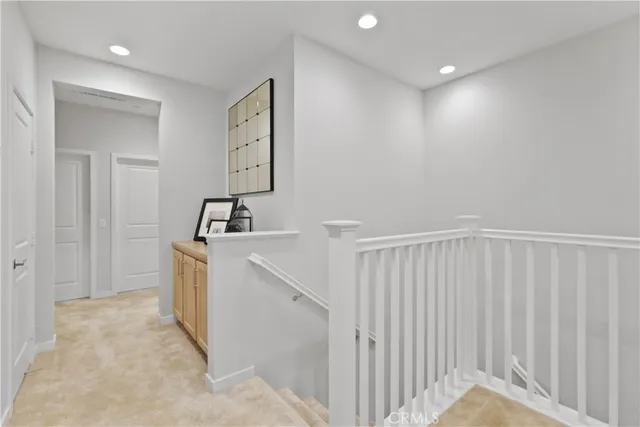 a bedroom with a bed a clock and a lamp on a table