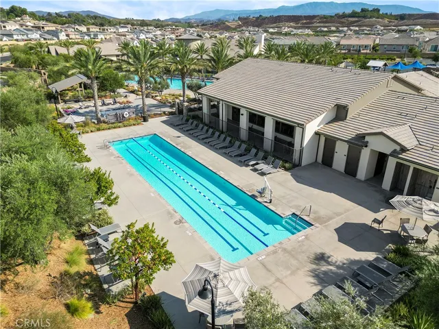 an aerial view of a house with swimming pool and furniture