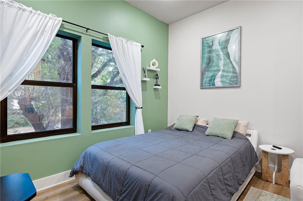 112 Rogers Street Northeast, Unit 202 Atlanta, GA 30317 - Photo 11 of 36 a bedroom with a bed and a painting on the wall