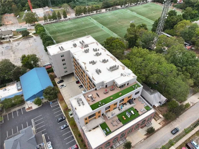 an aerial view of a residential building with garden space and street view