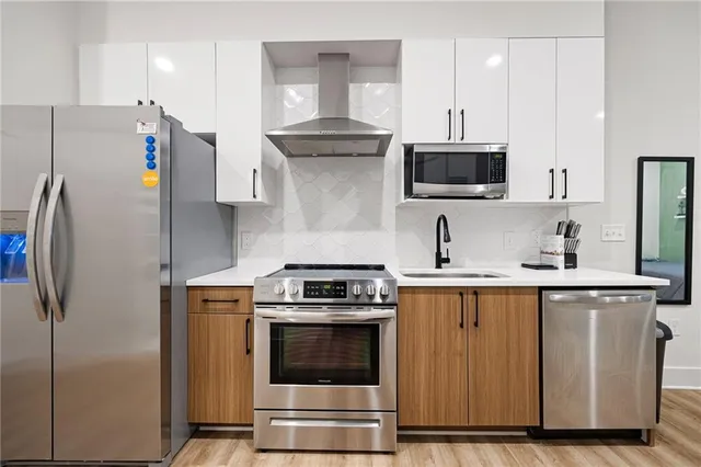 a kitchen with stainless steel appliances a refrigerator stove and microwave