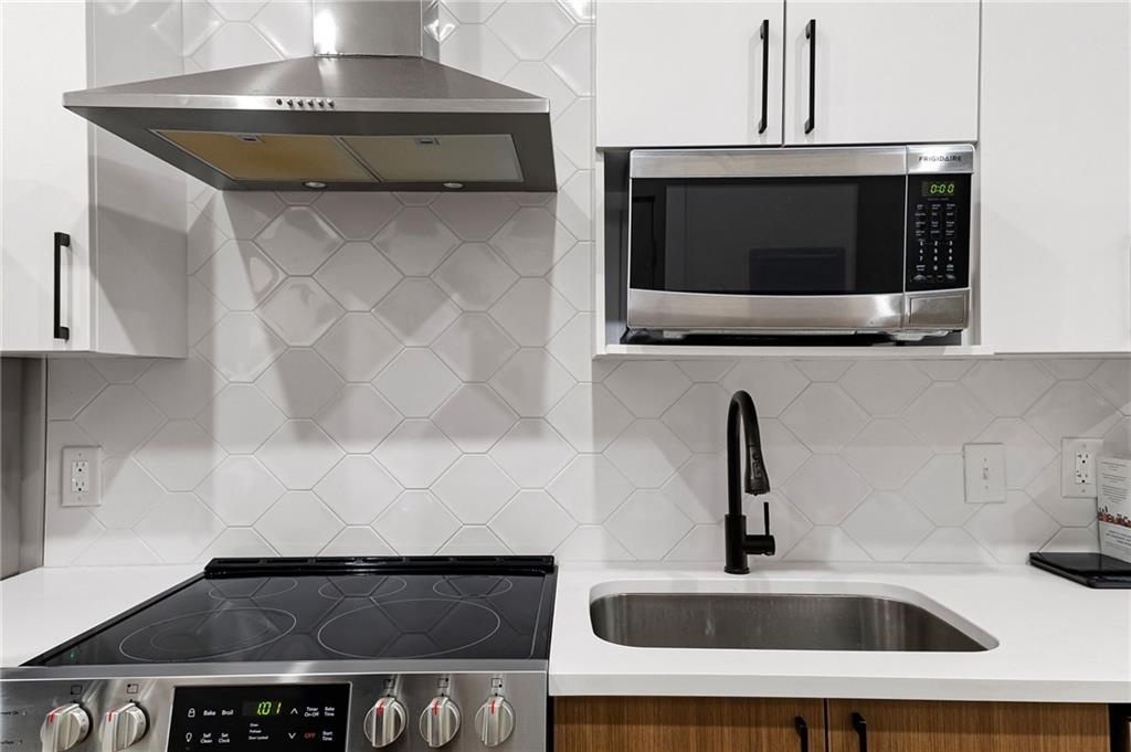 112 Rogers Street Northeast, Unit 202 Atlanta, GA 30317 - Photo 5 of 36 a kitchen with a stove and a microwave