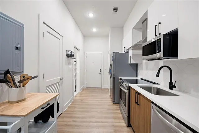 a kitchen with stainless steel appliances a sink and a refrigerator