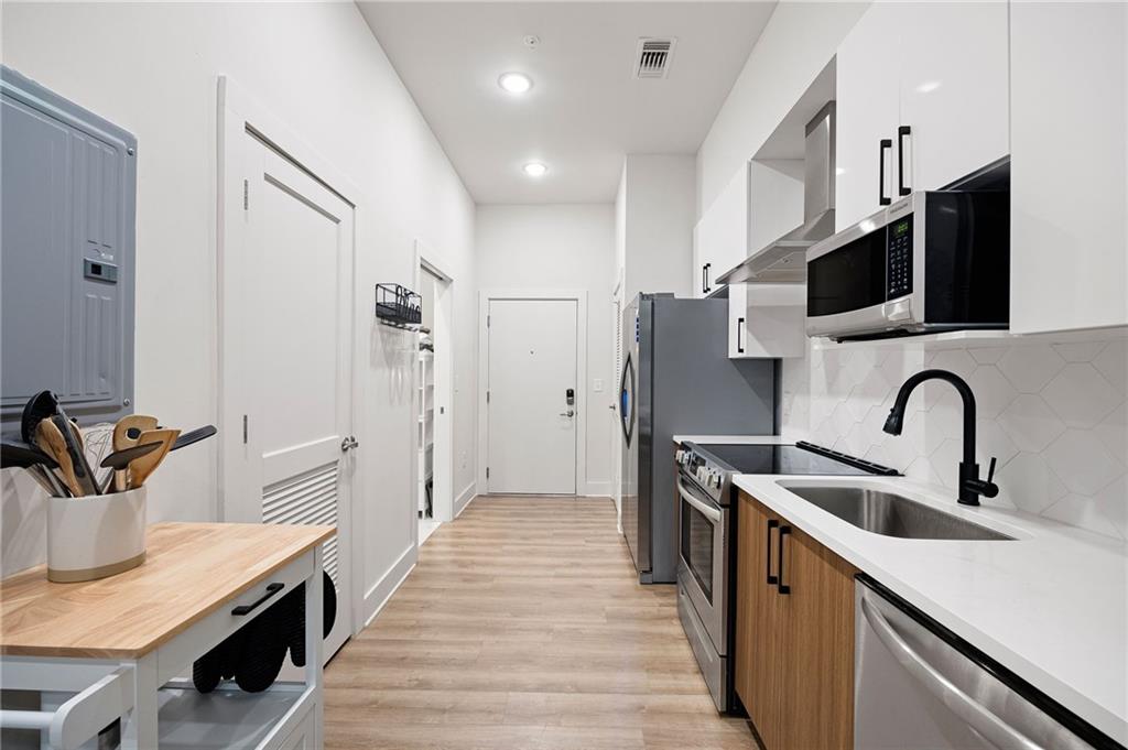 112 Rogers Street Northeast, Unit 202 Atlanta, GA 30317 - Photo 6 of 36 a kitchen with stainless steel appliances a sink and a refrigerator