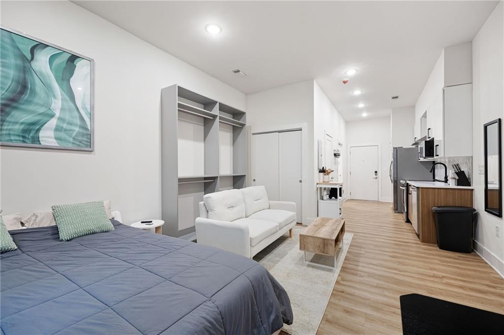 112 Rogers Street Northeast, Unit 202 Atlanta, GA 30317 - Photo 9 of 36 a spacious bedroom with a bed and a couch