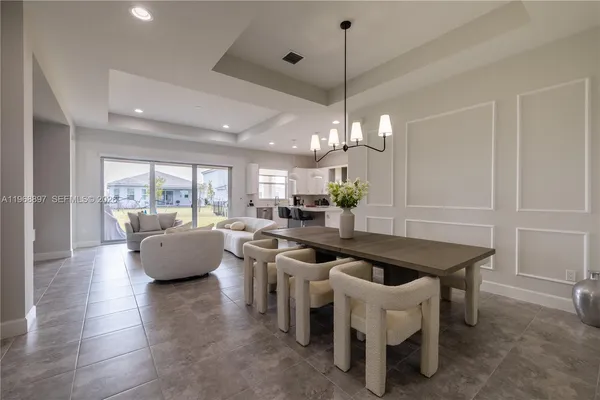 a kitchen with a table chairs and white cabinets