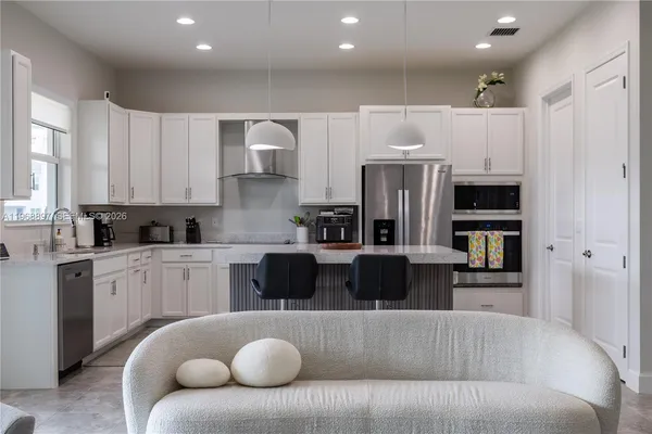 a kitchen with stainless steel appliances granite countertop a refrigerator and a stove top oven