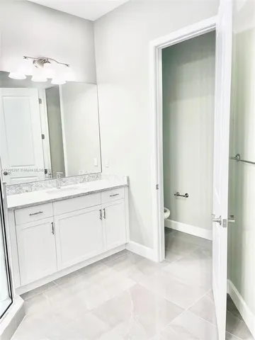a bathroom with a shower sink and mirror