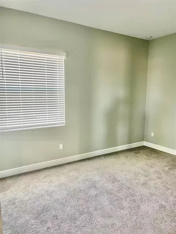a bathroom with a granite countertop sink vanity mirror and toilet