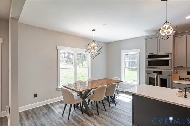 a kitchen with a sink a stove a oven a kitchen island with wooden floor and cabinets