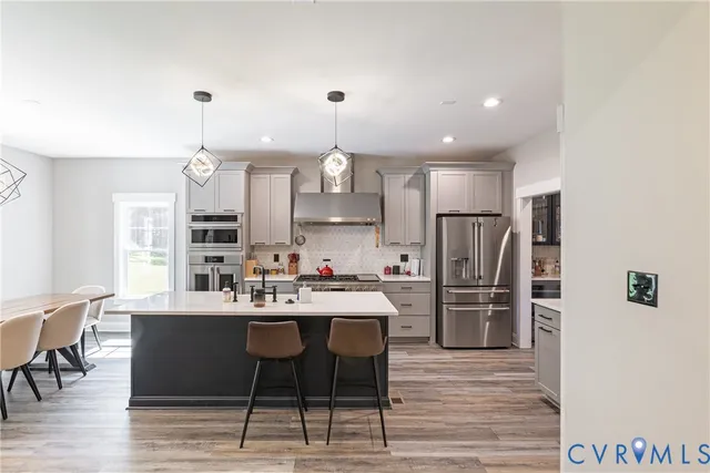 a kitchen with a white center island and stainless steel appliances