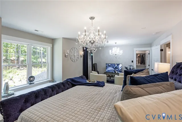 a spacious bedroom with a bed and chandelier