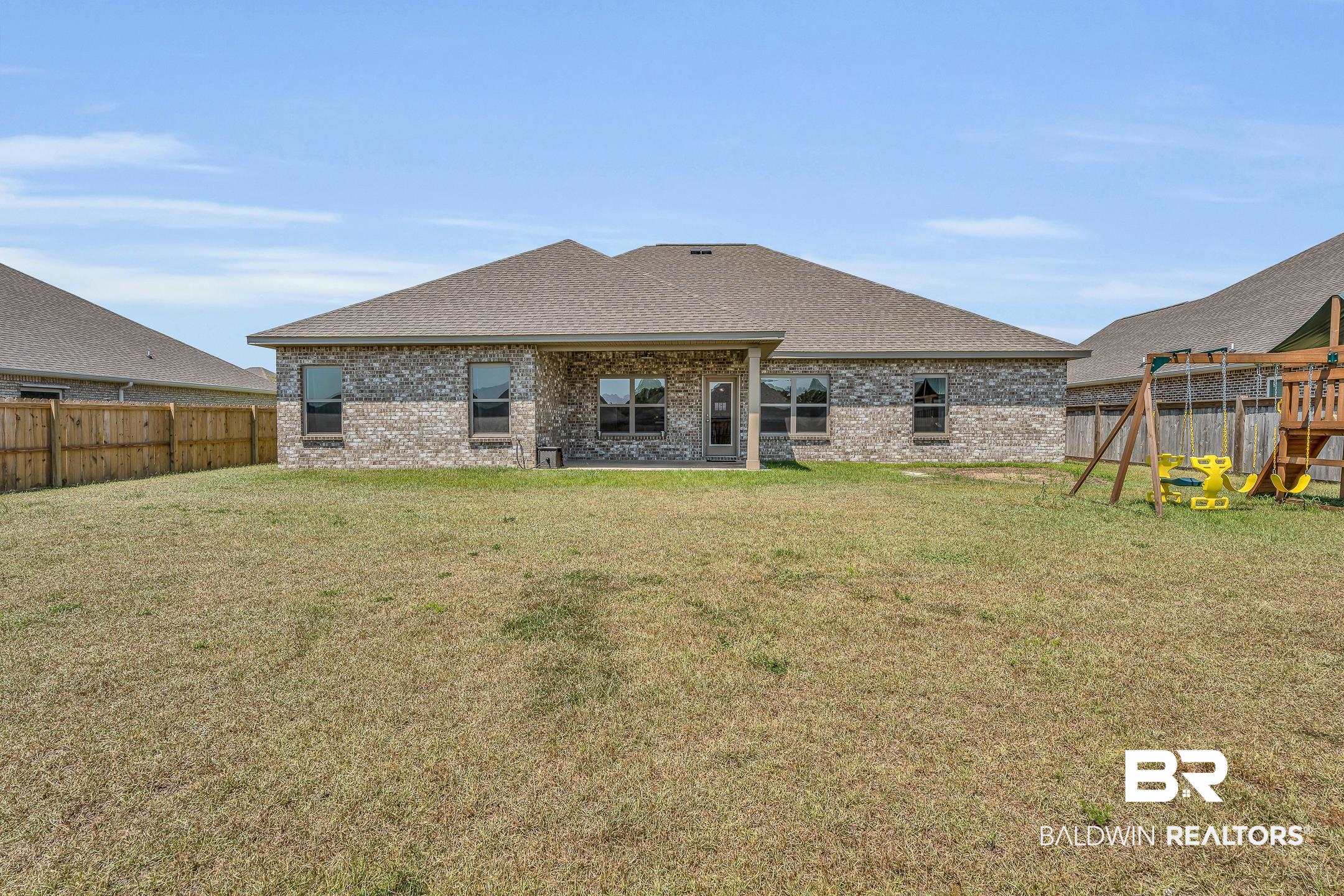 1720 Partridge Street Foley, AL 36535 - Photo 5 of 32 Rear view with covered rear porch, lawn and playground