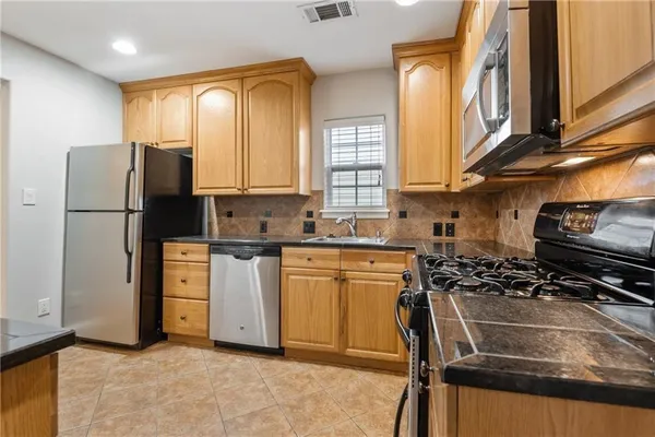 a kitchen with a refrigerator a stove a sink and a cabinets