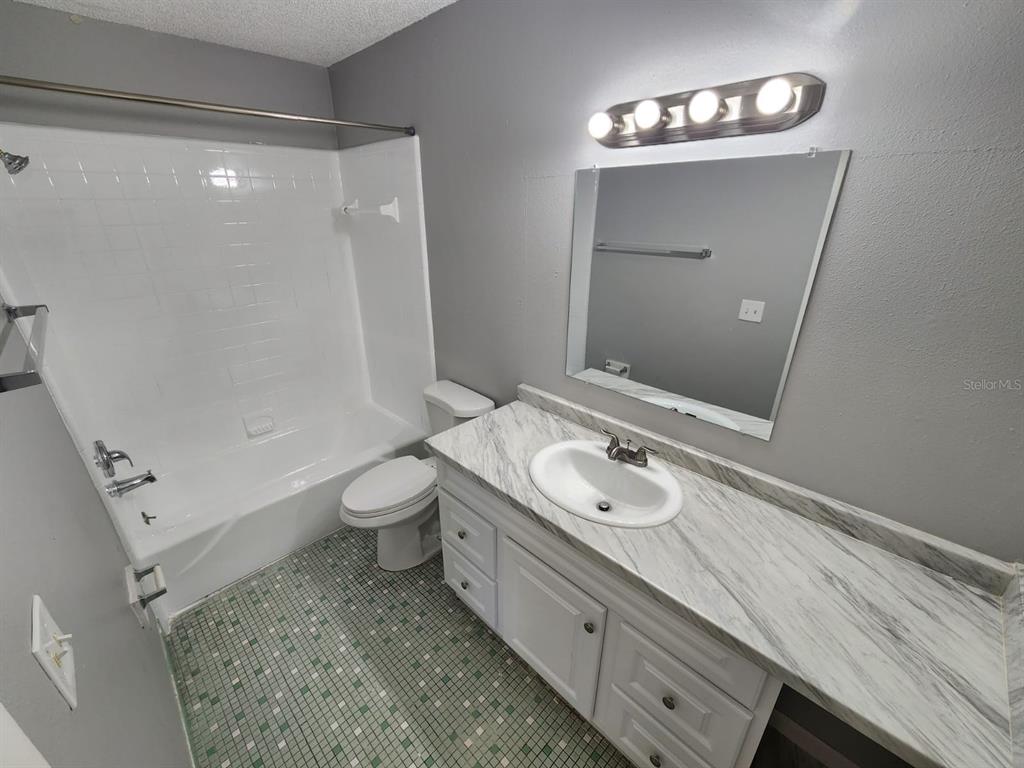 101 North Fernwood Avenue, Unit 6 Clearwater, FL 33765 - Photo 12 of 12 a bathroom with a sink a toilet and shower