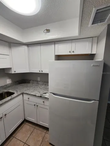 a kitchen with white cabinets and white appliances