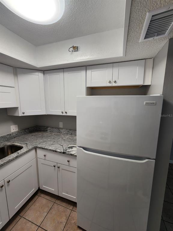 101 North Fernwood Avenue, Unit 6 Clearwater, FL 33765 - Photo 3 of 12 a kitchen with white cabinets and white appliances