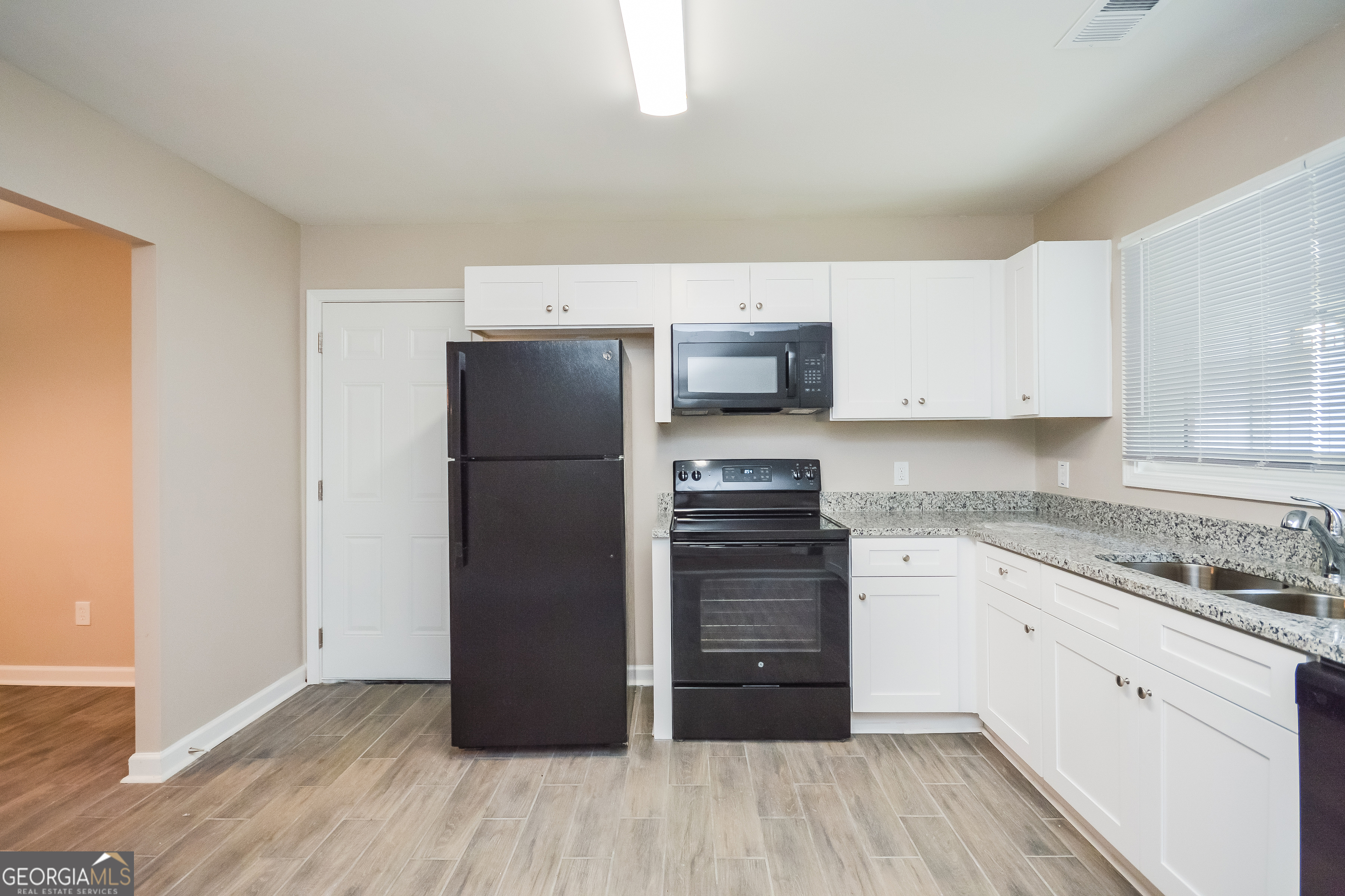 1534 Flicker Road Hampton, GA 30228 - Photo 13 of 16 a kitchen with granite countertop a refrigerator and a stove top oven