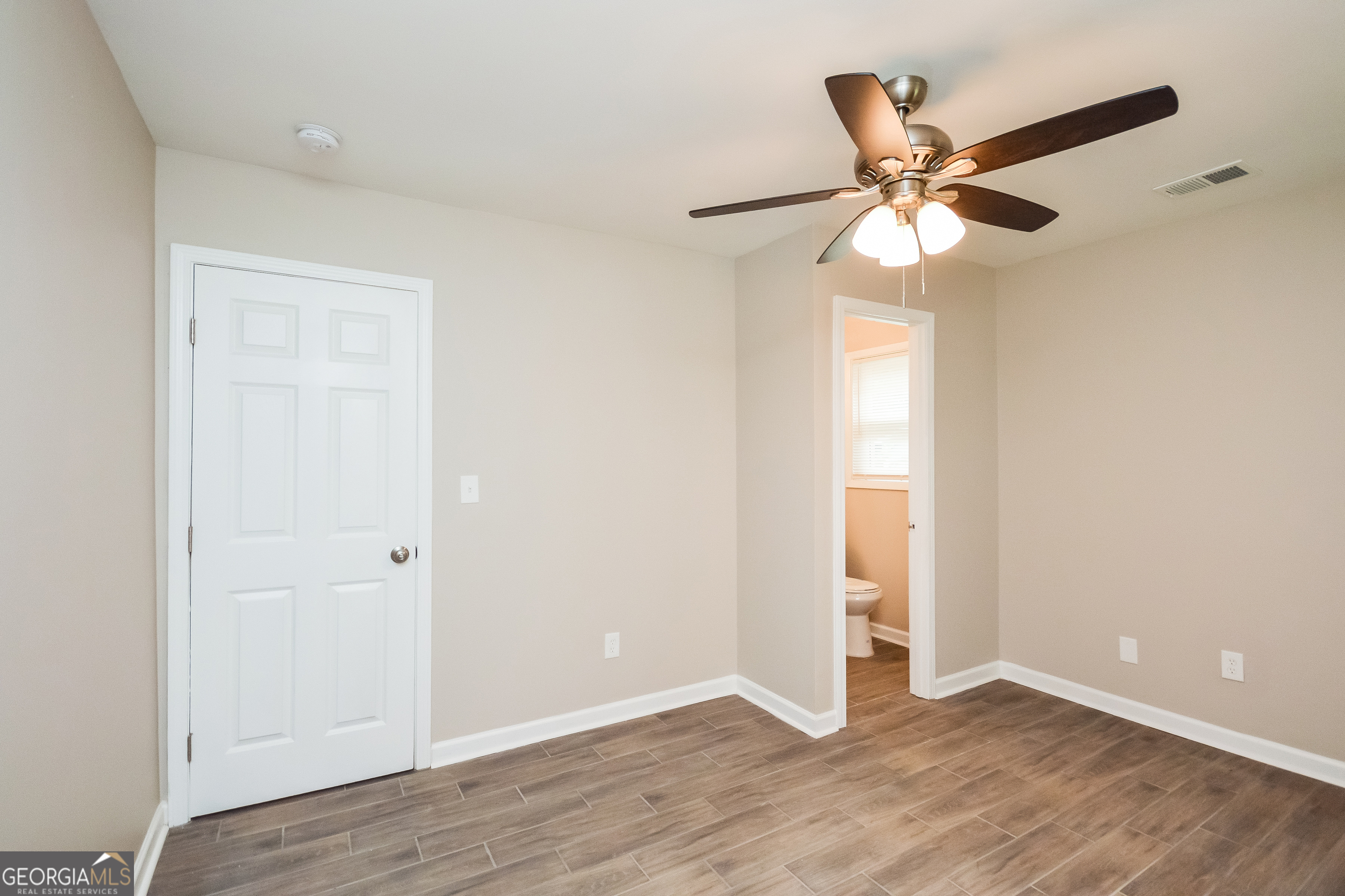 1534 Flicker Road Hampton, GA 30228 - Photo 14 of 16 an empty room with wooden floor closet and fan