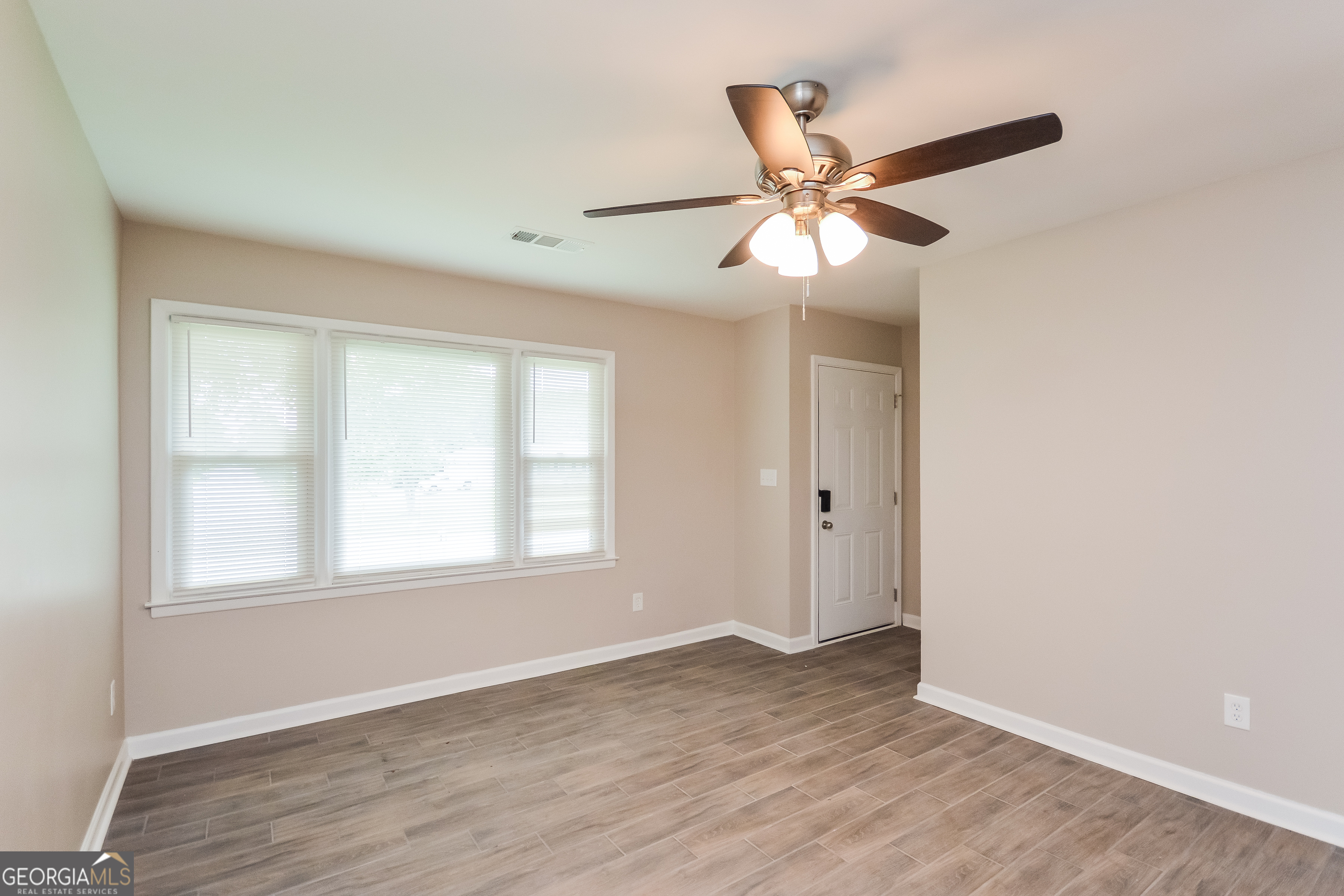 1534 Flicker Road Hampton, GA 30228 - Photo 16 of 16 a view of an empty room with wooden floor and a window