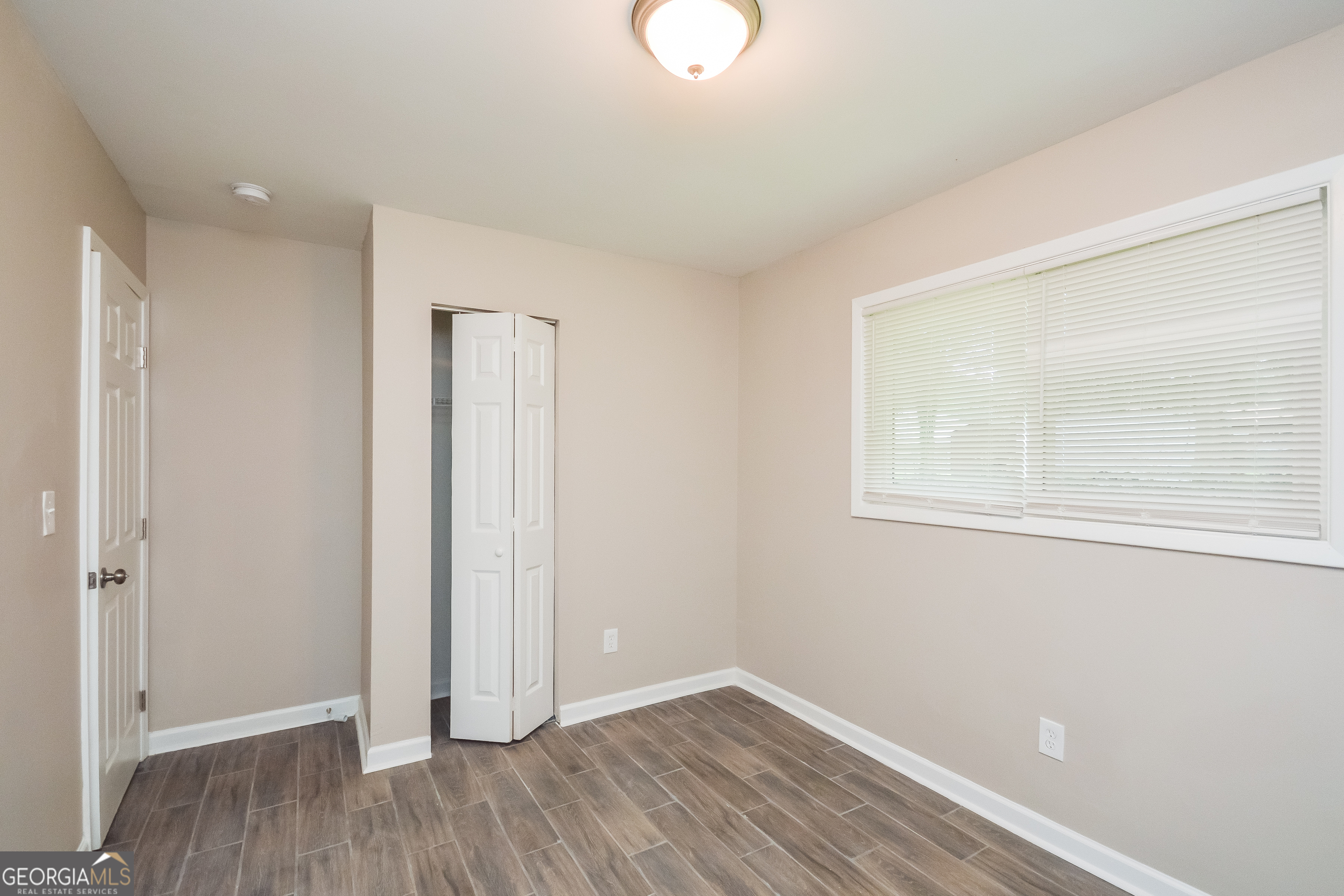 1534 Flicker Road Hampton, GA 30228 - Photo 5 of 16 an empty room with wooden floor and window