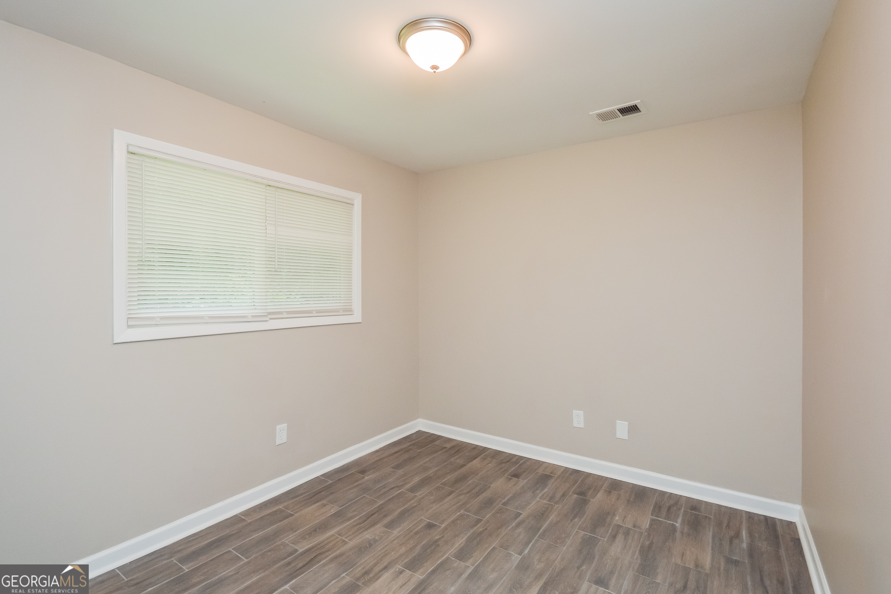 1534 Flicker Road Hampton, GA 30228 - Photo 6 of 16 an empty room with wooden floor and windows