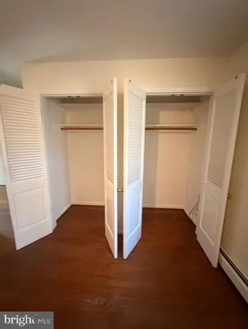an empty room with closet and wooden door
