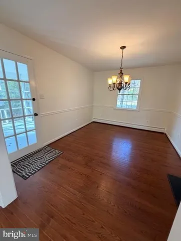 a view of a room with wooden floor and chandelier