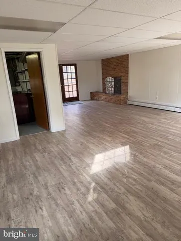 a view of a livingroom with wooden floor and a fireplace