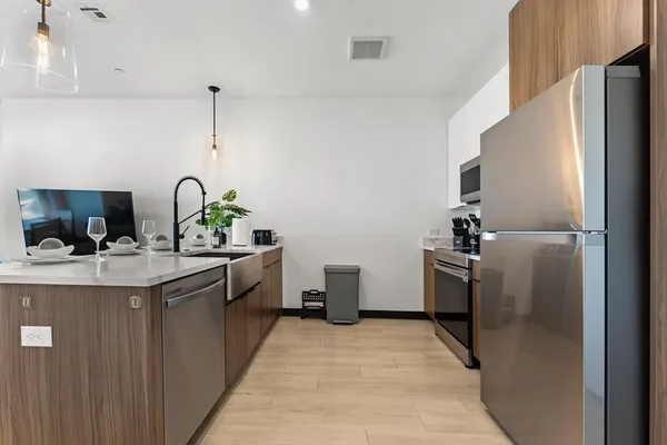 a kitchen with stainless steel appliances a sink stove and refrigerator