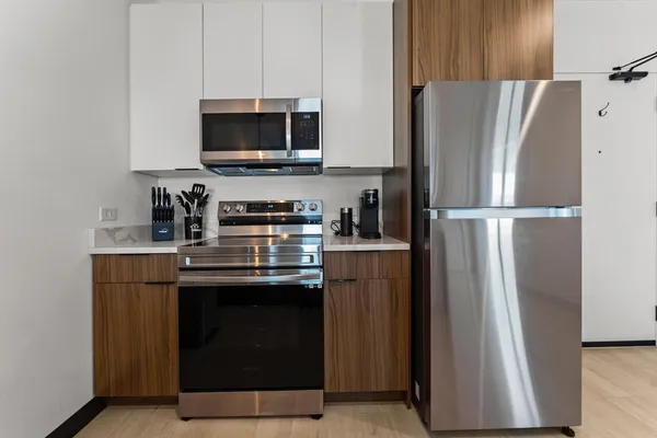 a kitchen with stainless steel appliances a refrigerator stove and microwave
