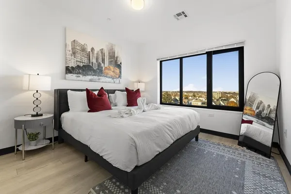 a bedroom with a bed and a large window