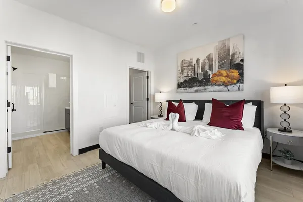 a bedroom with a bed and wooden floor