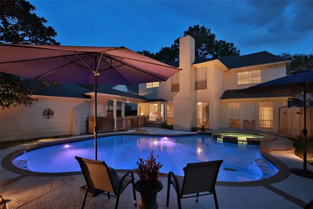 a view of a swimming pool with a table and chairs under an umbrella