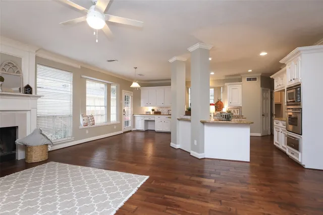 a large kitchen with cabinets wooden floor and a fireplace
