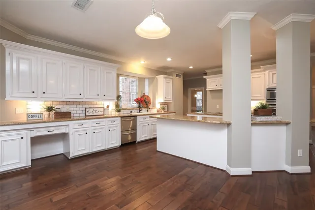 a kitchen with a refrigerator and white cabinets