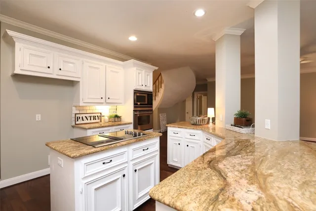 a kitchen with granite countertop a sink stove and cabinets