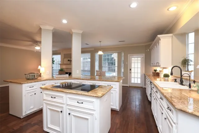 a kitchen with granite countertop a sink stove and cabinets
