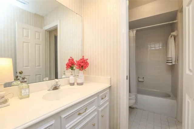 a bathroom with a granite countertop sink mirror and a shower