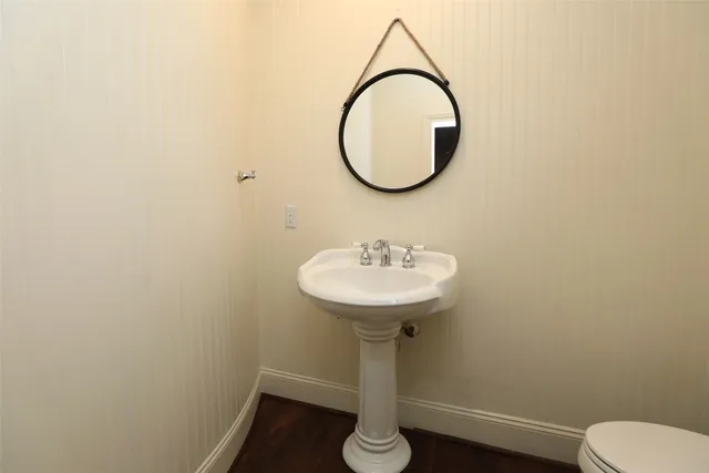 a bathroom with a sink toilet and a mirror