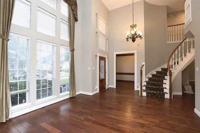 a view of a livingroom with wooden floor and stairs