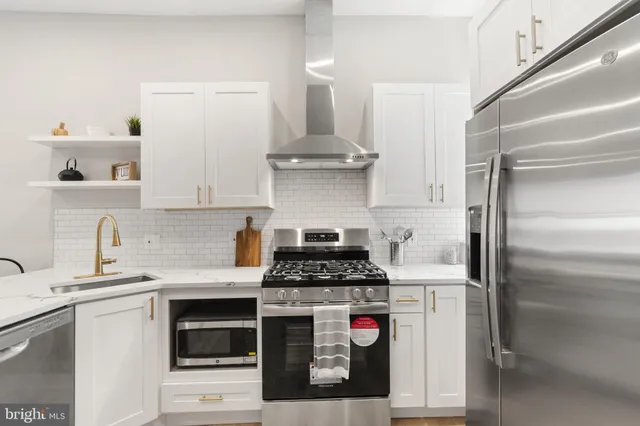 a kitchen with stainless steel appliances granite countertop a stove and a refrigerator