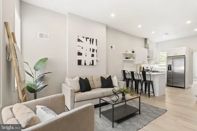 a living room with furniture and kitchen view