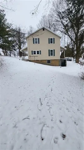 a view of the house with a snow in the yard