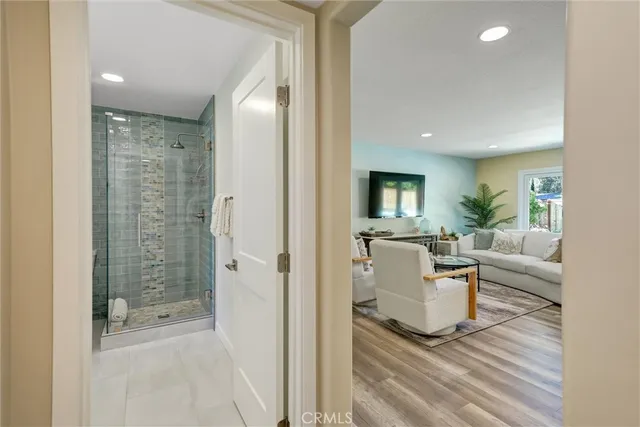 a spacious bedroom with a large bed a chandelier and windows