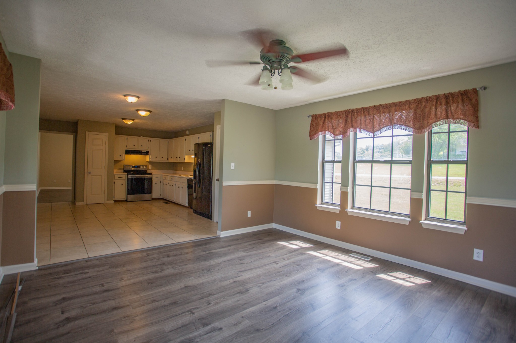 794 Chicken Road Lebanon, TN 37090 - Photo 9 of 25 a view of an empty room with a kitchen stove and wooden floor